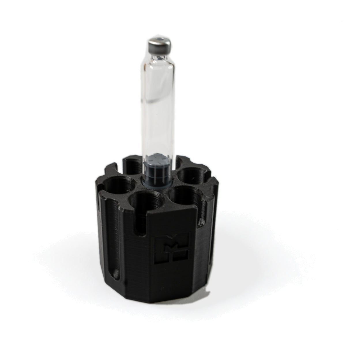 One 3 mL glass cartridge standing on the center purge post of the MODTECH purge station