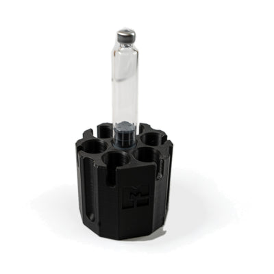 One 3 mL glass cartridge standing on the center purge post of the MODTECH purge station