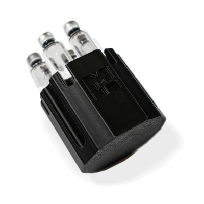 MODTECH purge station holding 3 mL glass cartridges upright, seen at an angle with the M logo forward