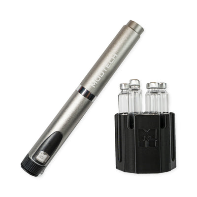 Silver MODTECH V2 pen leaning beside the purge station holding six 3 mL glass cartridges
