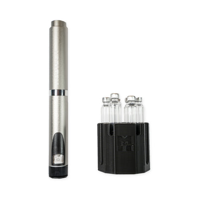 Silver MODTECH V2 pen standing beside the purge station holding six 3 mL glass cartridges