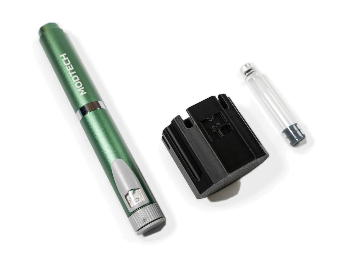 Green MODTECH V2 pen beside the black purge station and one 3 mL glass cartridge
