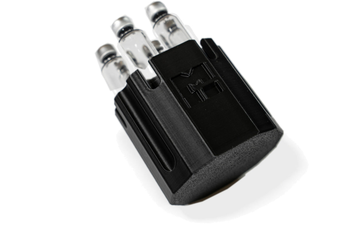 MODTECH black purge station with the M logo, holding 3 mL glass cartridges upright in its slots