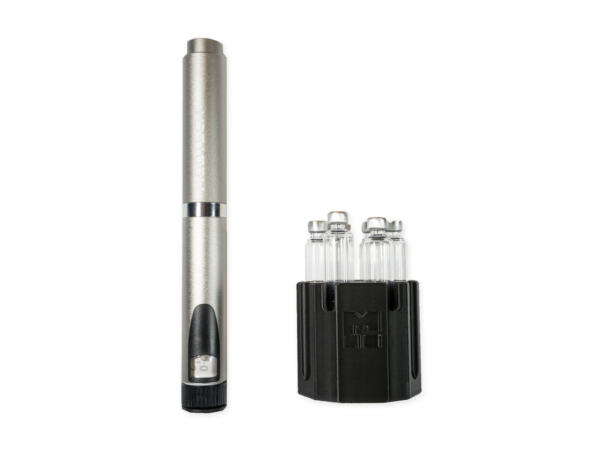 Silver MODTECH V2 pen standing beside the black purge station holding six 3 mL glass cartridges