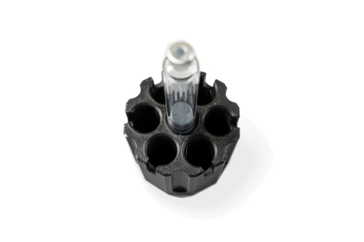 One 3 mL glass cartridge standing on the center purge post of the MODTECH purge station, seen from above